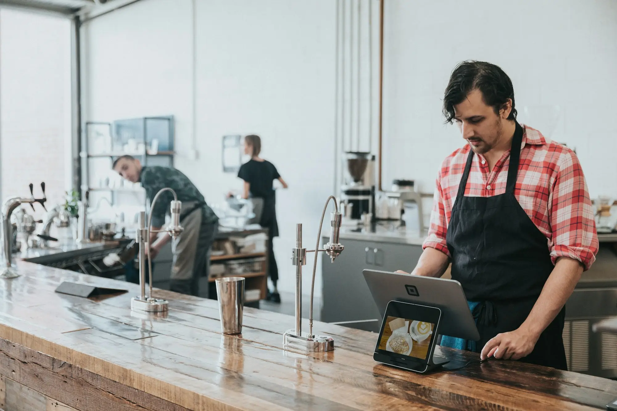 Cafe owner checking the business accounts on a laptop at the counter of a Sydney cafe